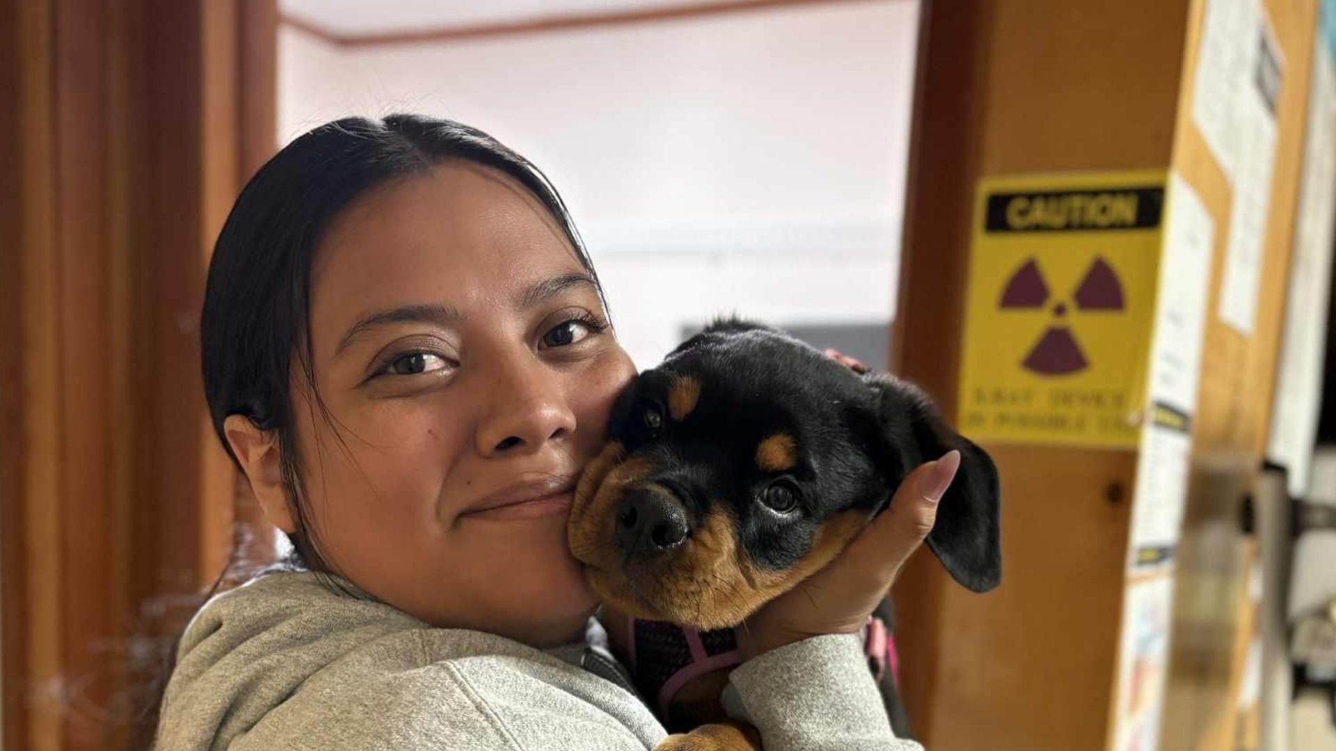 A woman cradles a small dog in her arms